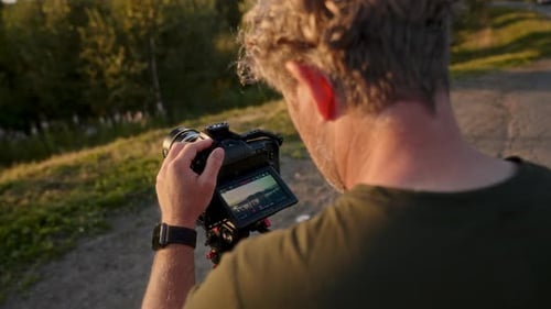 Man Using Camera Outdoors at Sunset