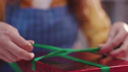 Hands Tying Ribbon on a Birthday Gift