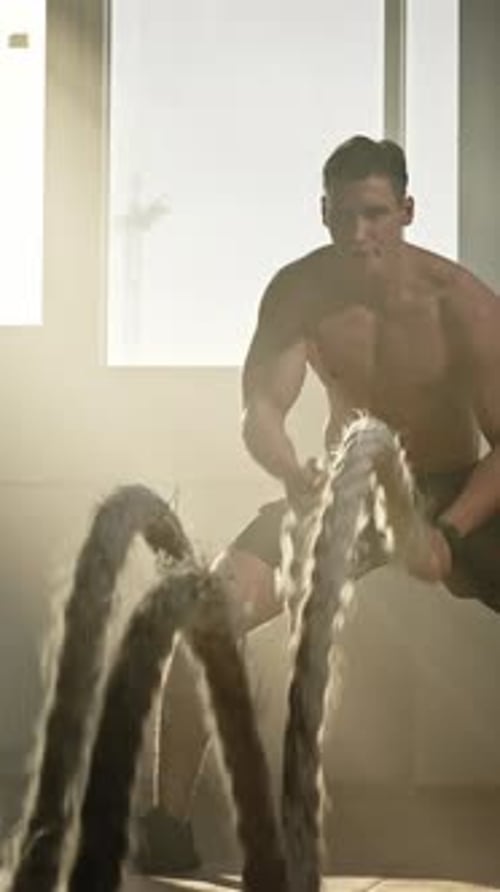 Muscular Man Works Out with Battle Ropes