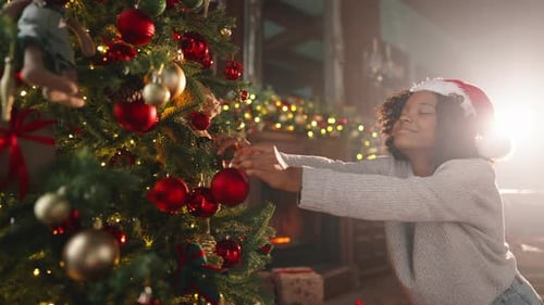Girl Decorates Christmas Tree With Shiny Ornaments