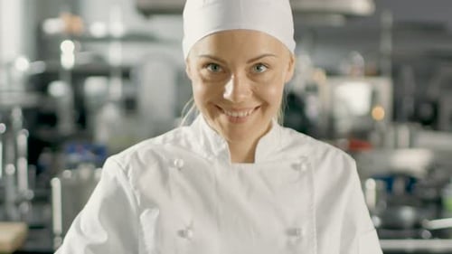Beautiful Young Female Chef Smells Decorative Spice Plant.