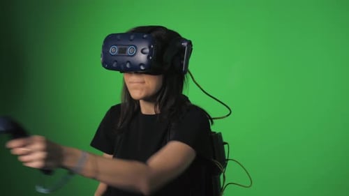 Concepto de Vídeo de realidad virtual Una mujer con unos auriculares especiales para realidad virtual con joysticks