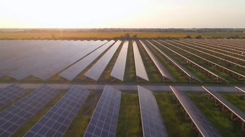 Aerial Drone View of Large Solar Panels at a Solar Farm at Bright Sunset in Early Winter