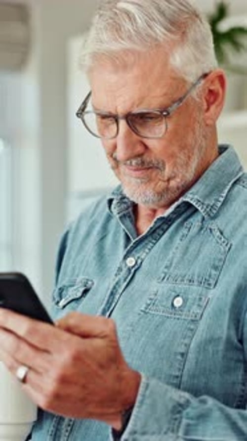 Man using cell phone and drinking coffee indoors