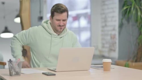 Adult Man Experiencing Back Pain at Desk