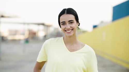 Smiling young woman looking at camera outdoors