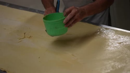 artisan bakery, baker making bread and pastry, dough kneading, egg with brush in dough