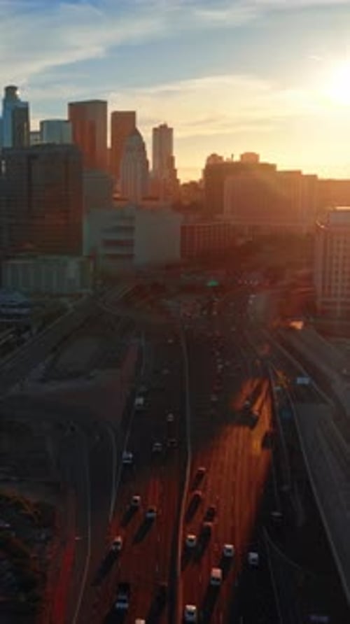 Multiple cars move by the roads and stand on the parking lots.