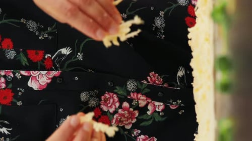 Adult Prepares Food by Shredding Cheese Indoors