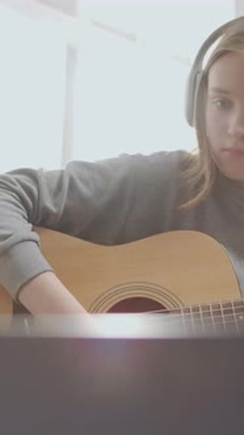 Teen Girl Learning Guitar at Home with Headphones