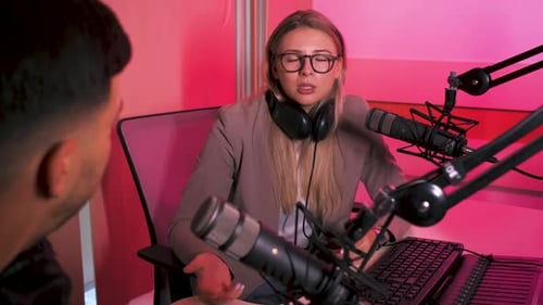 Female podcaster making podcast with young man from her studio.