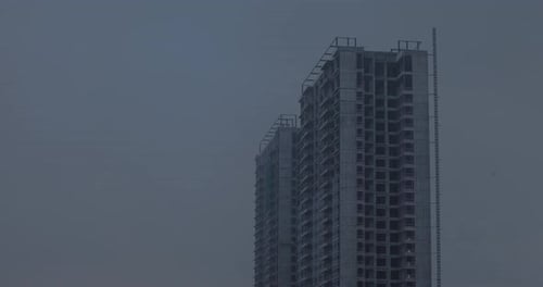 Time lapse of building construction with cloud moving in the blue sky and change into a rainstorm
