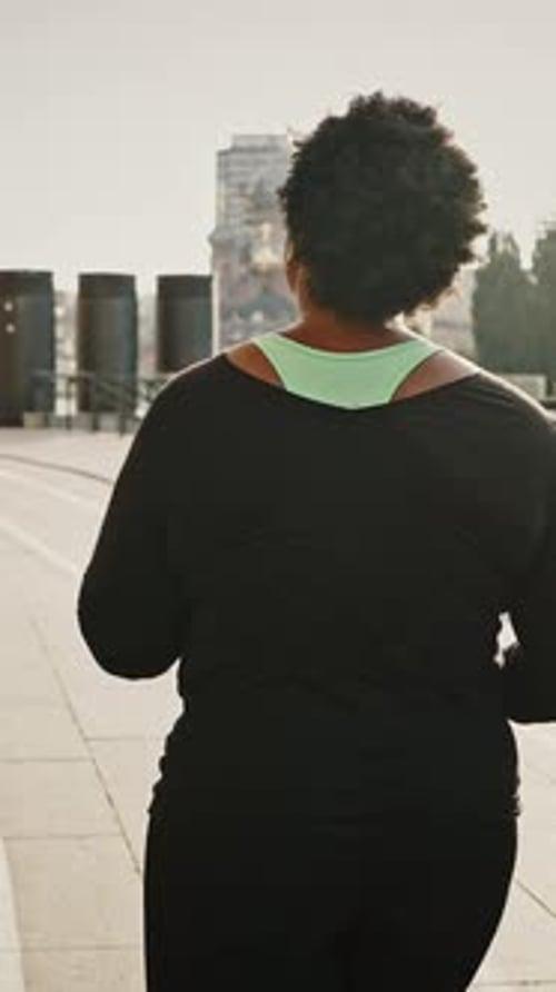 Morning Jog and Weight Loss Concept Back View of Overweight African American Woman Running in City