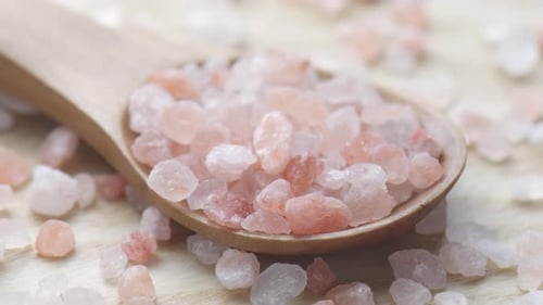 Closeup view of wooden spoon with Himalayan salt crystals
