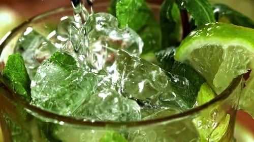 Pouring Refreshing Drink with Lime and Mint