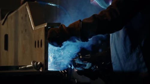 Welder Using Welding Torch during Metal Fabrication Process at Factory