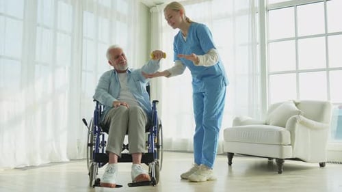 Senior Man Exercising with a Caregiver in Bright Room