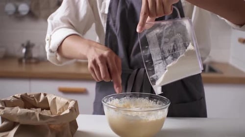 Hausfrau, junge Mutter, bereitet Teig zum Backen von Pfannkuchen zu, kocht Teig zum Backen