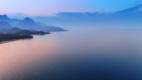 Idyllic view of the beautiful calm waterscape colored pink at dusk time.