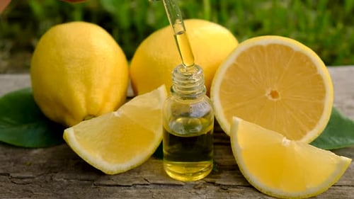 Fresh Lemons and Lemon Extract on Wooden Table