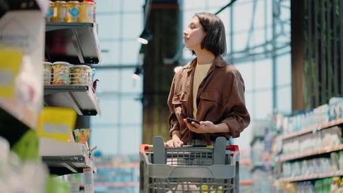Woman Shopping with Smartphone in Grocery Store