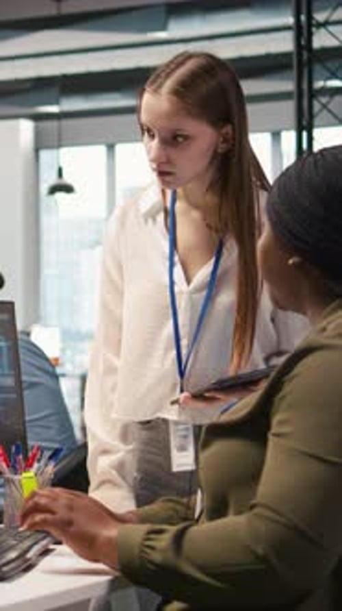 Colleagues Collaborate on Computer in Modern Office
