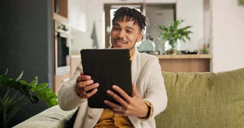 Young Man Smiling on Tablet in Home Setting