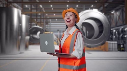 Side View Of Asian Female Engineer Working On A Laptop at Heavy Factory