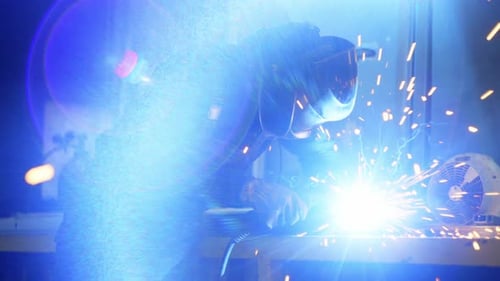 Un ingeniero de soldadura suelda estructuras metálicas en el taller