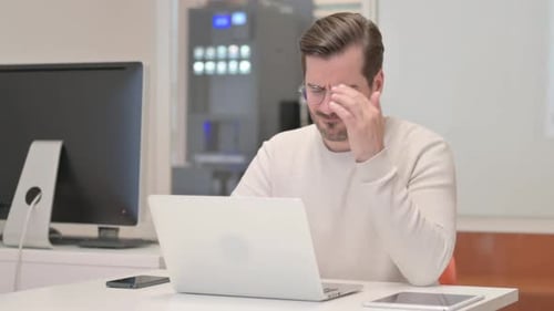 Man with Headache at Computer in Office