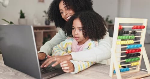 Mother and Daughter Using Laptop Together at Home