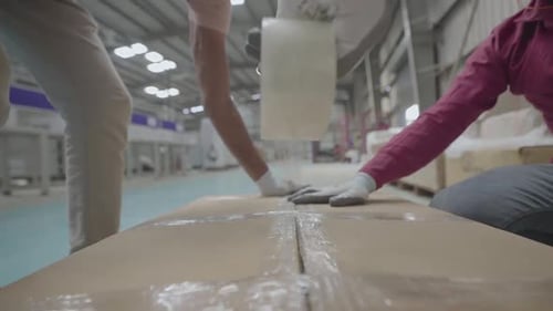 Worker Packing Boxes With Tape for Shipment