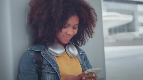 Young Woman Using Phone Outdoors in Urban Setting