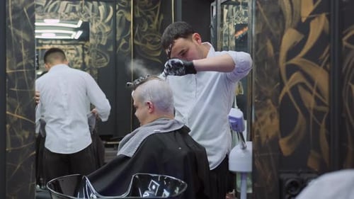 Barber Cutting Man's Hair in Modern Barbershop