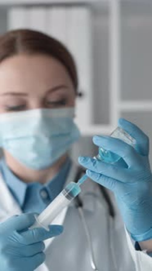 Doctor Prepares Syringe for Injection in Hospital