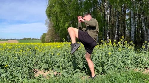 Young Adult Practicing Martial Arts in Flower Field