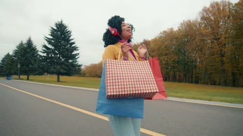 Young Woman Enjoys Shopping in Autumn Park