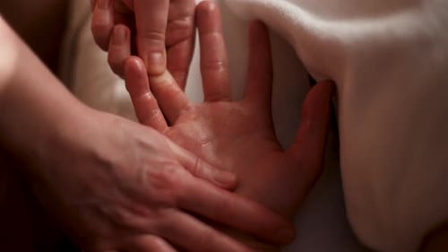 Closeup Hands of Unrecognizable Female Massage Therapist Doing Massage of Finger and Palm to Male