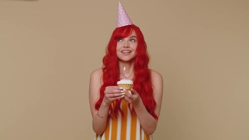 Cheerful Woman Celebrating Birthday with Cupcake and Candle