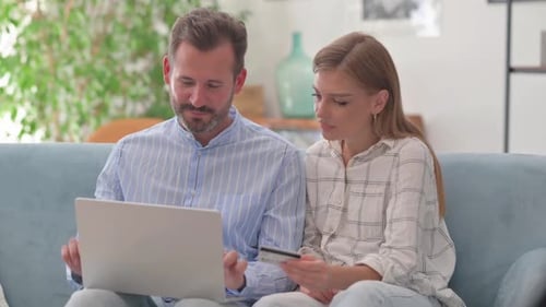 Happy Couple Shopping Online At Home With Laptop
