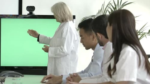 Medical professional presenting to team using chroma key screen