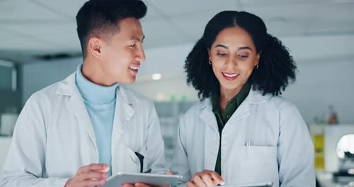 Scientists Collaborating Using Tablets in Modern Lab