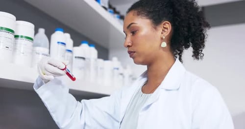 Female Scientist Examining Test Tube in Lab