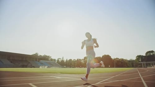 Beautiful Fitness Woman in Light Blue Athletic Top and Leggings is Starting a Sprint Run in an Outd