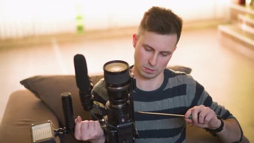 Man Assembling a Video Camera Rig at Home