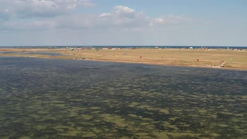 People go kitesurfing on the sea. The wind carries the athlete along the sea waves.