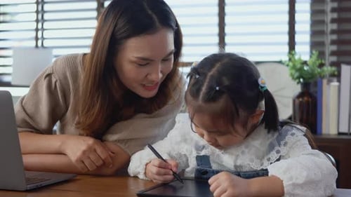 Mother Watches Daughter Drawing on Tablet at Home