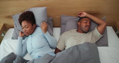 Ci-dessus, frustration et couple au lit avec ronflement, bruit fort ou congestion nasale à la maison
