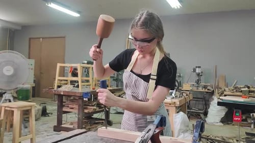 Young female carpenter working in a workshop, Knocking Wood