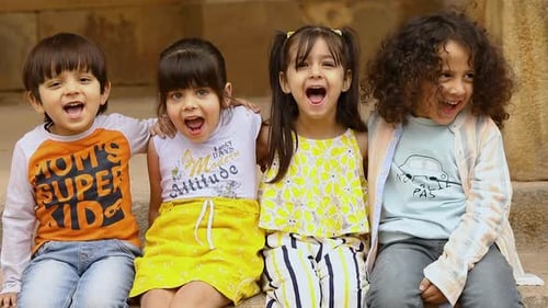 Four Smiling Children on Stone Steps Yelling